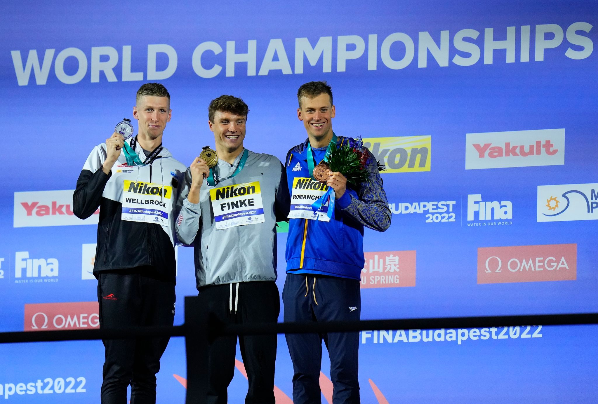 Der Zweitplatzierte Florian Wellbrock (l-r), Sieger Bobby Finke aus den USA, und der Ukrainer Michailo Romantschuk auf dem Podium.