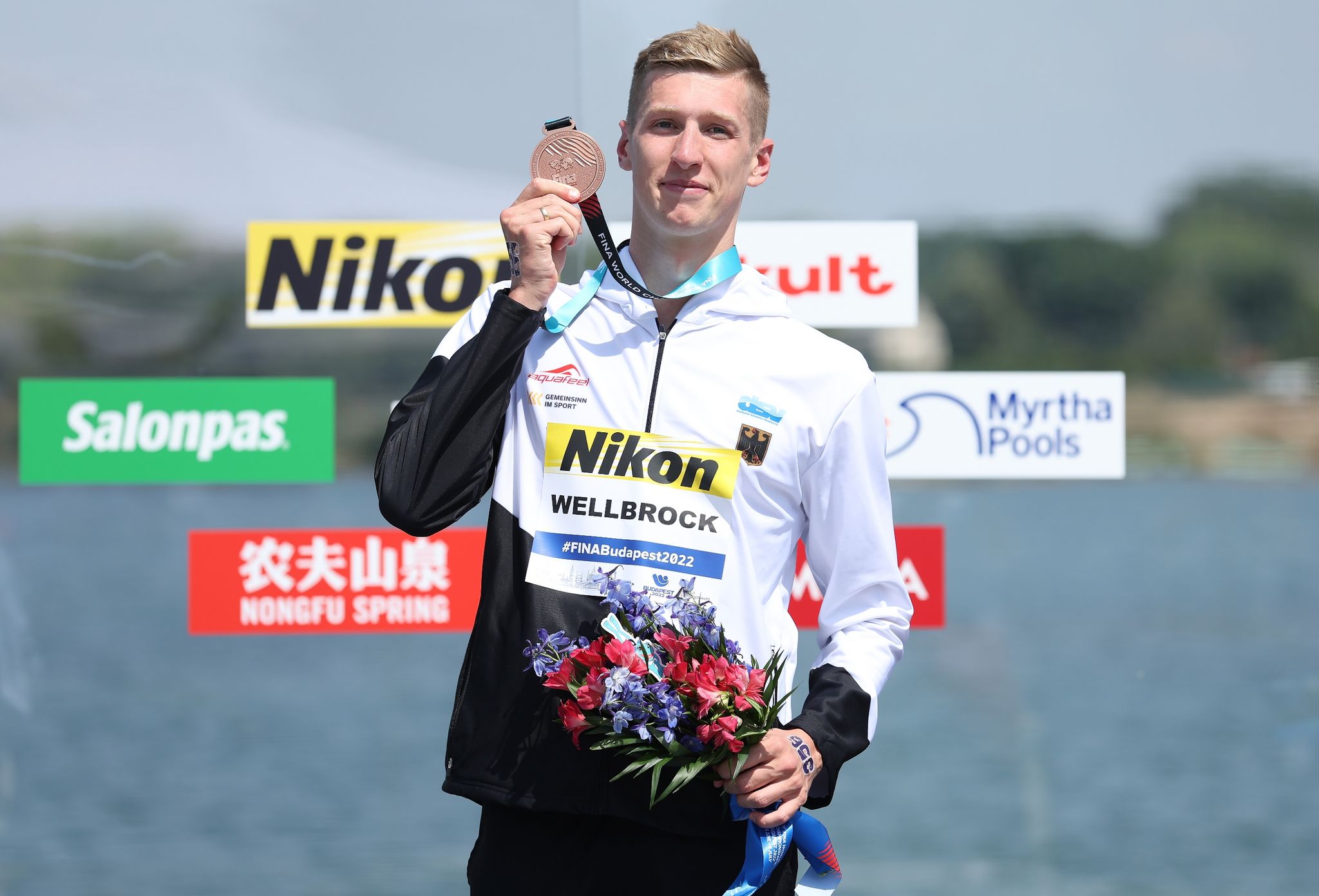 Florian Wellbrock präsentiert seine Bronzemedaille.