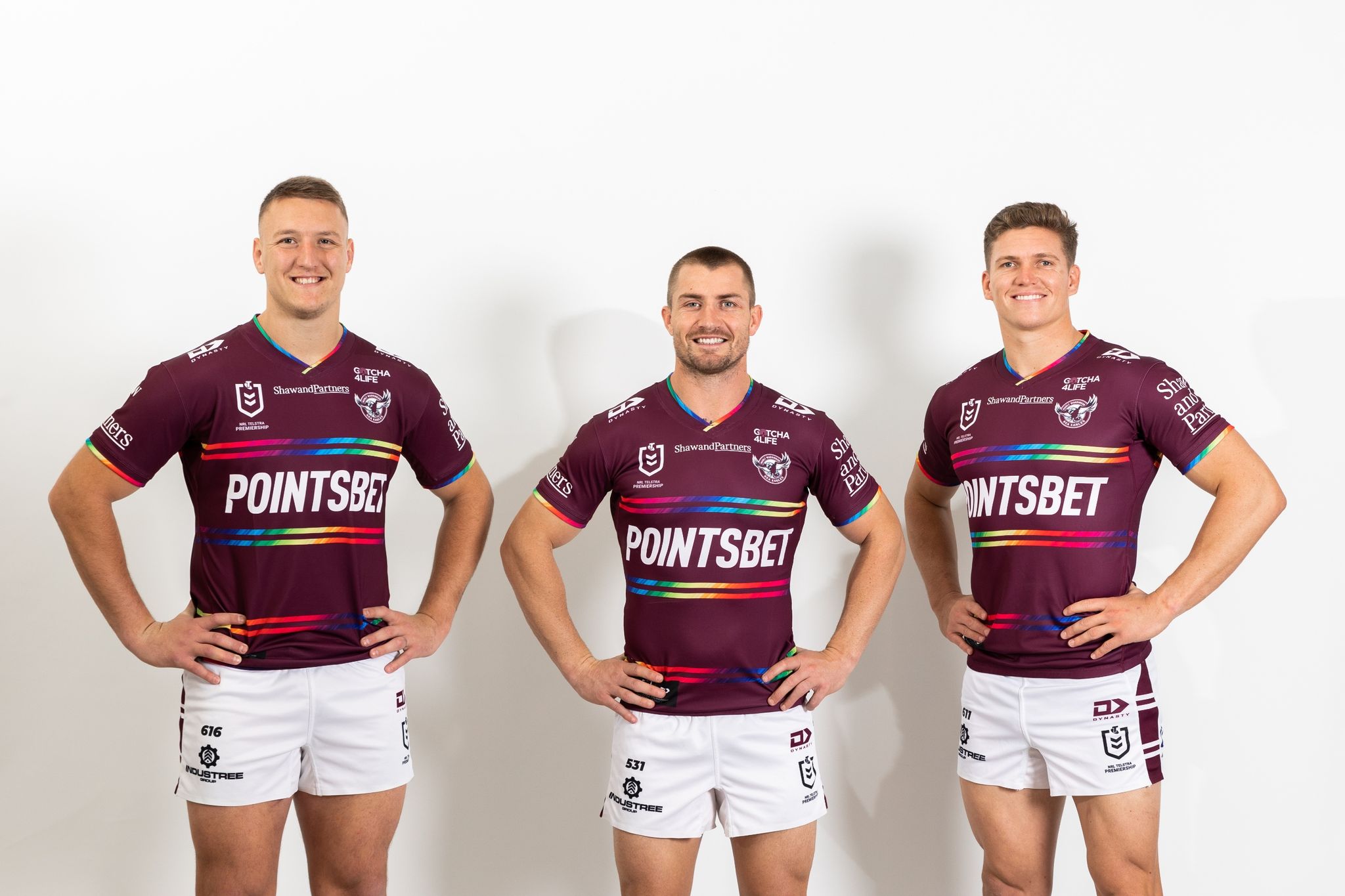 Drei Spieler des australischen Rugby-Legue-Clubs Manly Warringah Sea Eagles posieren mit dem Regenbogen-Trikot.