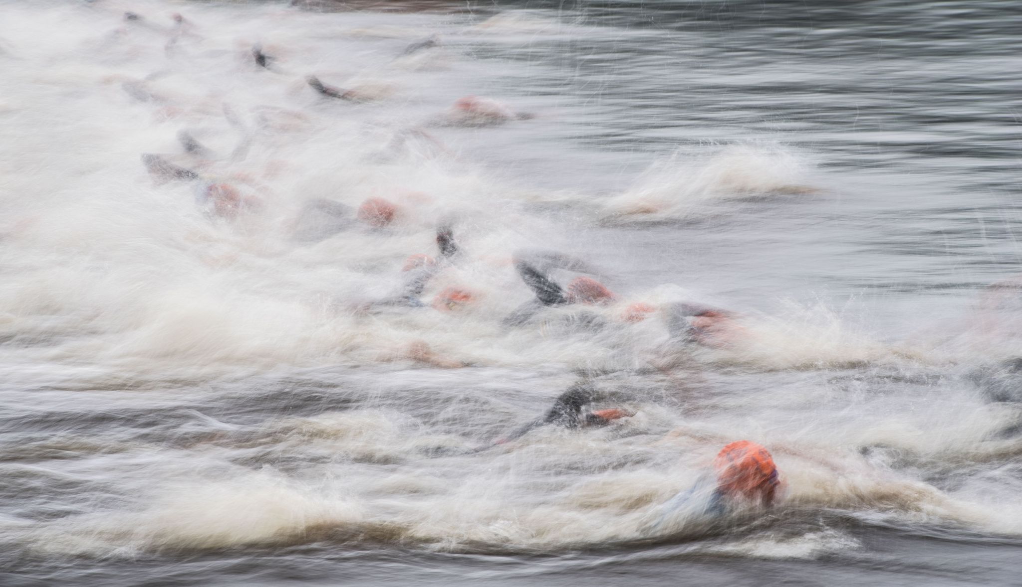 Triathleten schwimmen im Wasser.