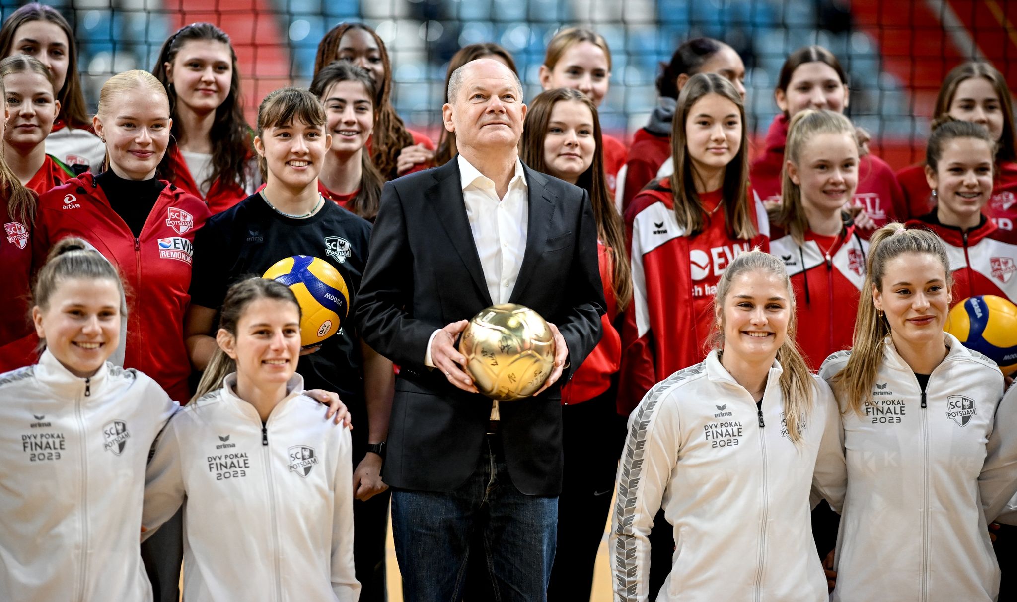 Bundeskanzler Olaf Scholz (SPD) steht bei einem Besuch zwischen den Spielerinnen des SC Potsdam.