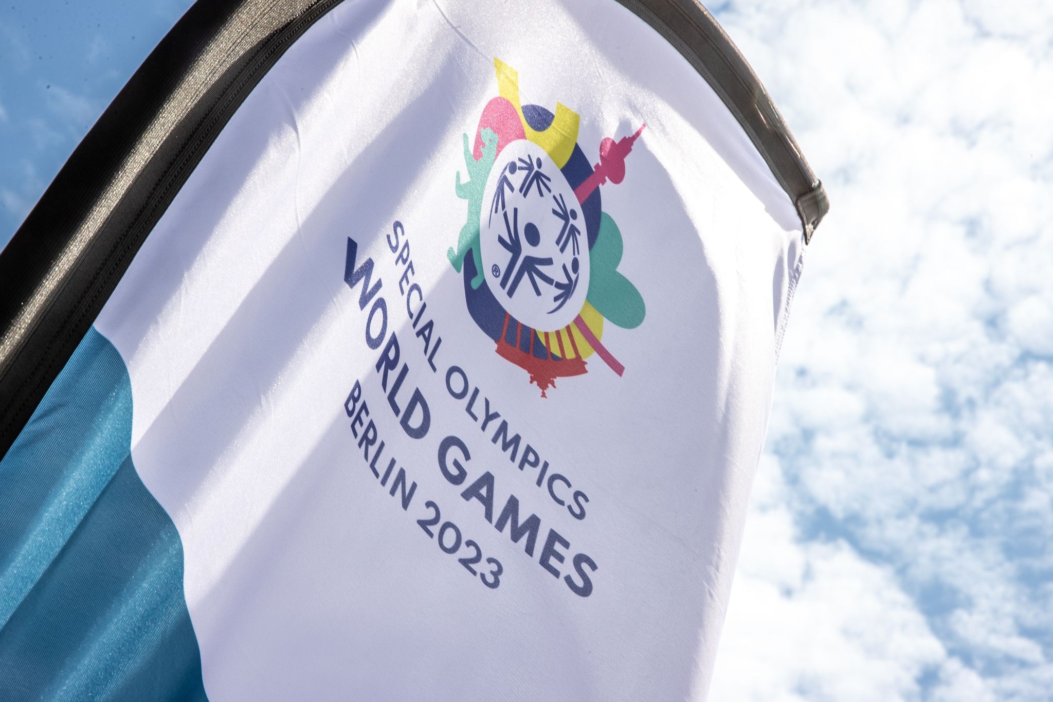 Eine Fahne der Special Olympics World Games Berlin 2023 weht auf dem Gelände des Olympiaparks in Berlin.