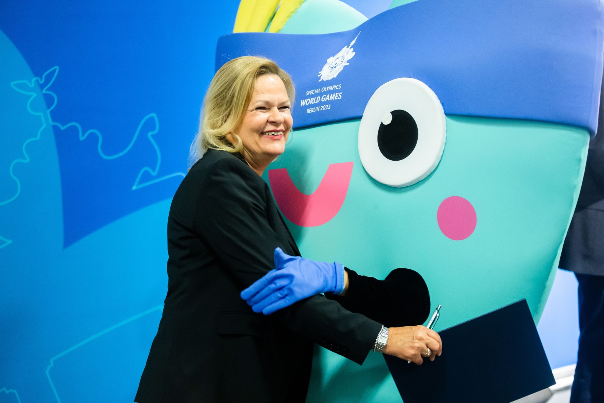 Bundesinnenminister Nancy Faeser umarmt das Maskottchen «Unity» der Special Olympics World Games.