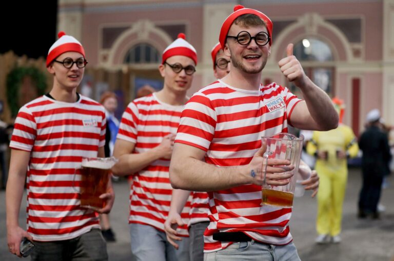 Darts-Fans in Kostümen und Bierkrügen auf dem Weg ins  Alexandra Palace.