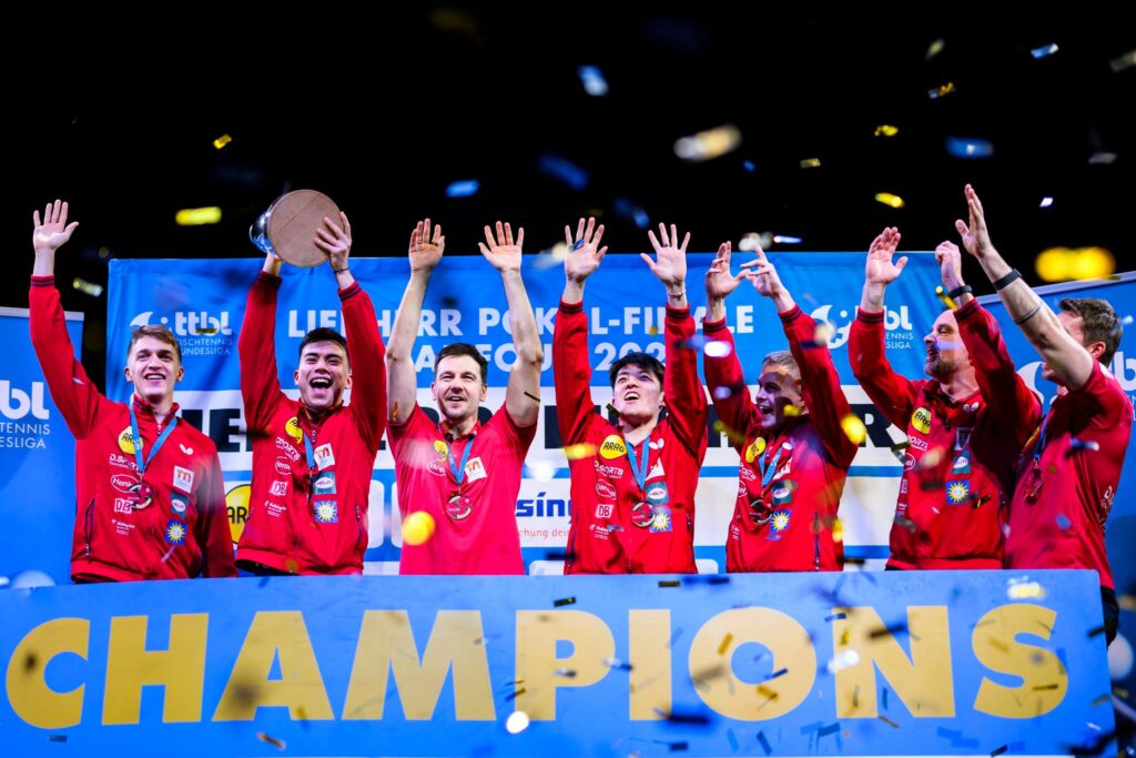 Kay Stumper, Timo Boll, Dang Qiu, Borgar Haug und Trainer Danny Heister jubeln bei der Siegerehrung.