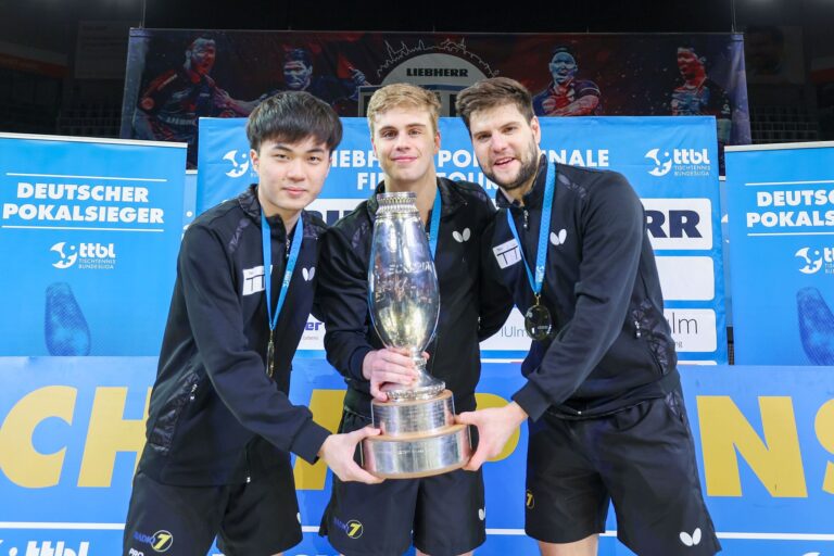 Lin Yun-ju (l-r), Truls Moregardh und Dimitrij Ovtcharov, alle von TTC Neu-Ulm, jubeln mit dem Champions-League-Pokal. In der Bundesliga spielt der Verein nicht mehr mit.