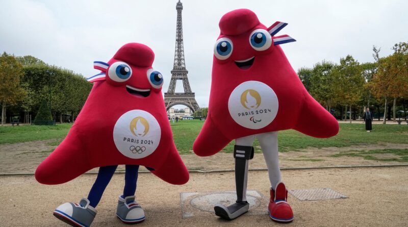 Die Maskottchen der Olympischen (l) und Paralympischen Spiele in Paris stehen vor dem Eiffelturm.