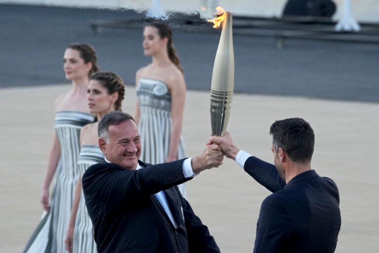 Der Präsident des französischen Organisationskomitees, Tony Estanguet (r), nahm die olympische Flamme in Athen entgegen.