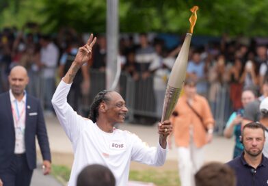 Rap-Star Snoop Dogg trägt die olympische Flamme.