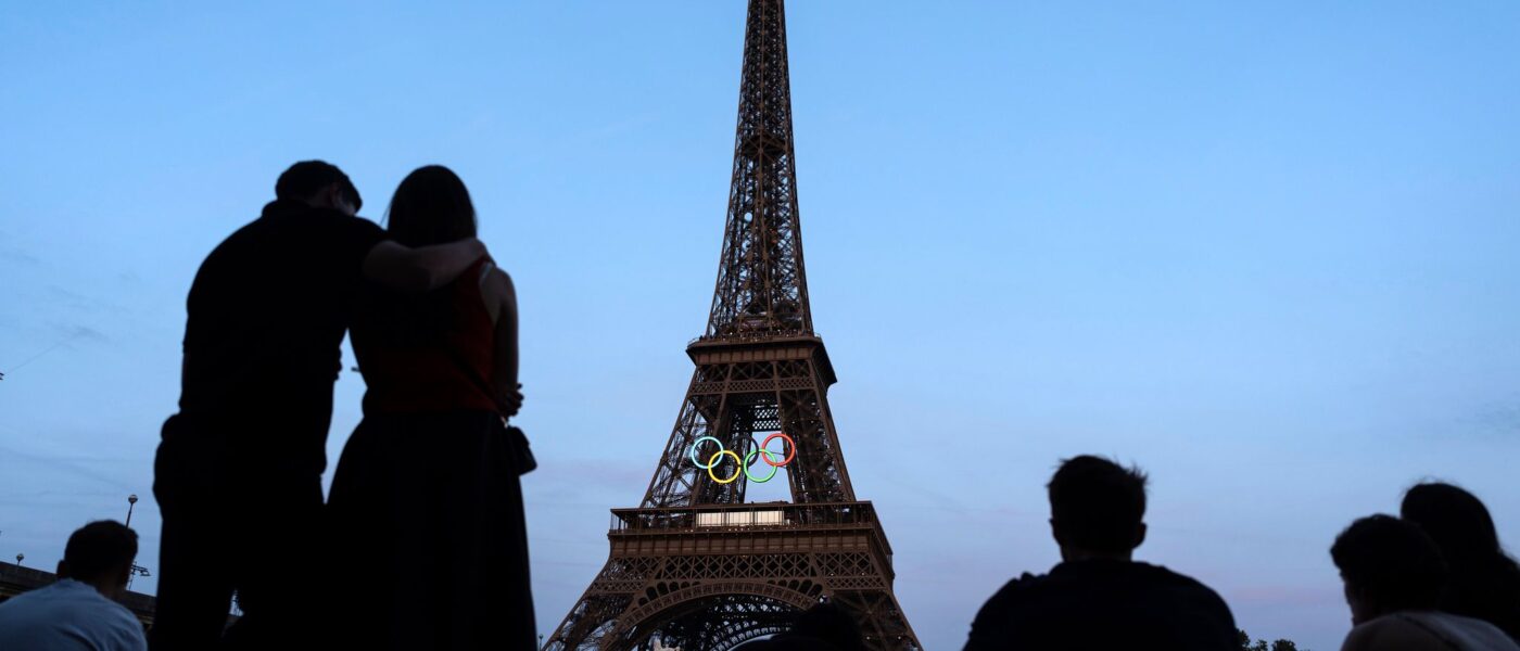 Paris-Touristen vor dem mit den olympischen Ringen geschmückten Eiffelturm.