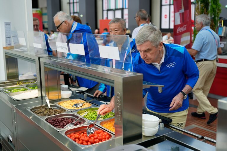 IOC-Präsident Thomas Bach (r) testete auch das Essen im olympischen Dorf.