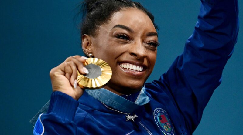 Simone Biles zeigt stolz ihre sechste olympische Goldmedaille.