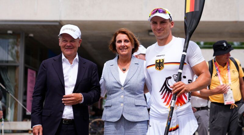 Bundeskanzler Olaf Scholz (l) und seine Frau Britta Ernst lassen sich mit Olympiasieger Tom Liebscher-Lucz fotografieren.